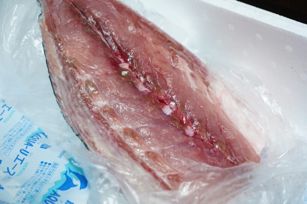 Yellowtail fillet resting on a moisture-absorbing sheet